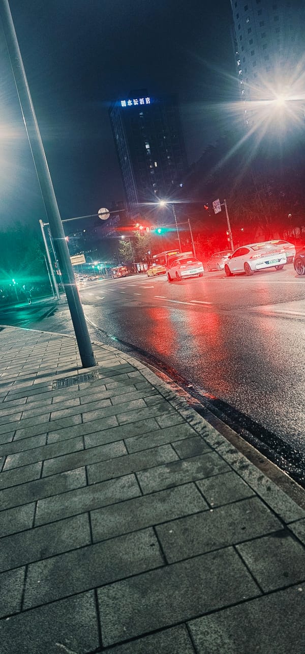 Wet night street scene with traffic in Jiulongpo District
