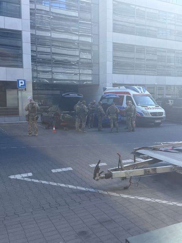 Military personnel gather around ambulance on Warsaw street