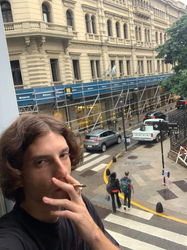 Person smoking hand-rolled cigarette observed on Buenos Aires street