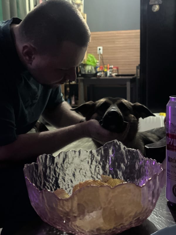 Man smokes hookah with dog in purple-lit Blagoveshchensk room