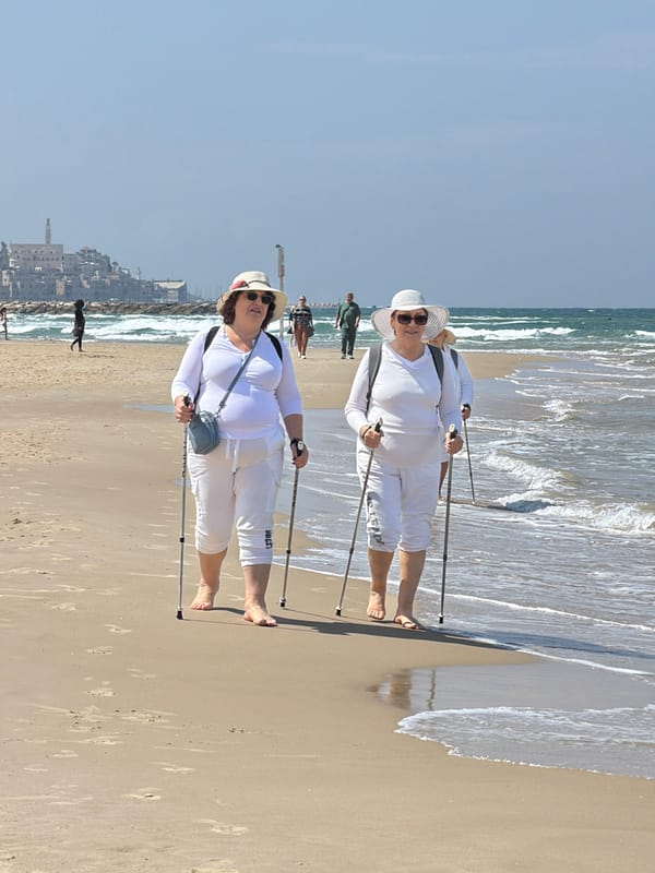 Elderly women Nordic walking on Tel Aviv beach morning