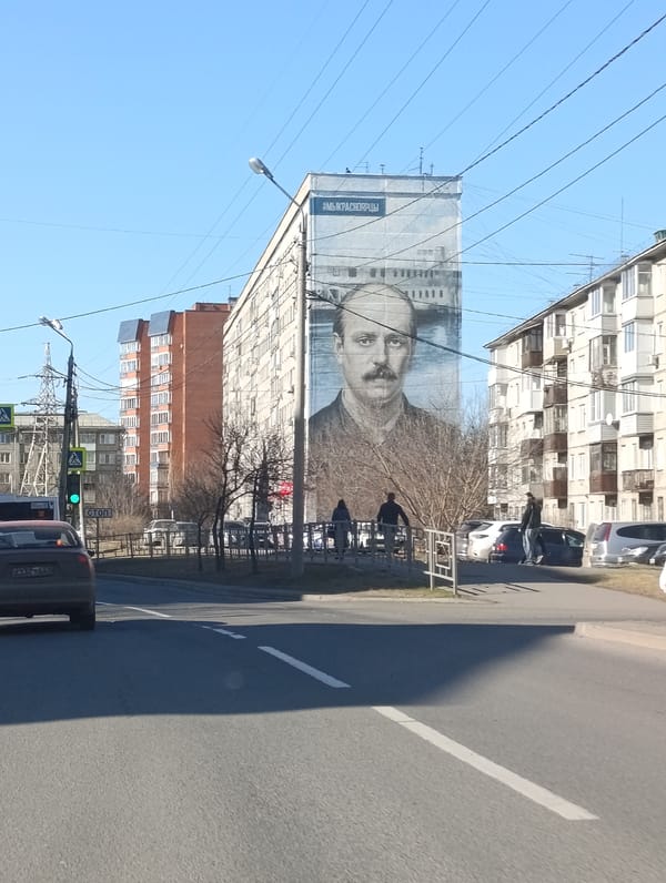 Street scenes documented in Krasnoyarsk showing apartment buildings, mural