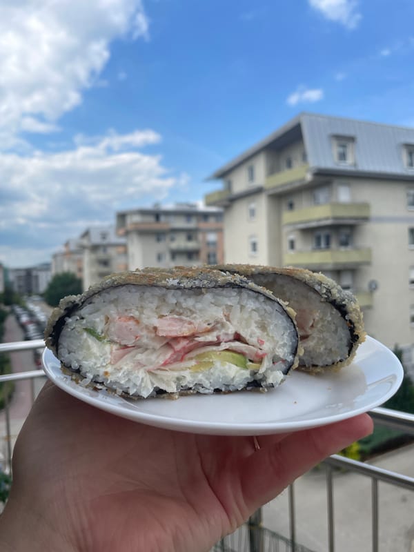 Outdoor lunch featuring deep-fried sushi rolls and beverages documented