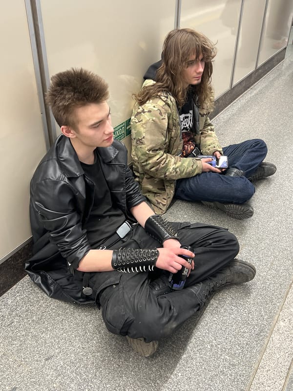 Two people sit on subway station floor in Saint Petersburg