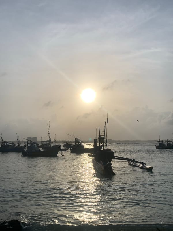 Fishing boats anchored off the hazy coast of Midigama
