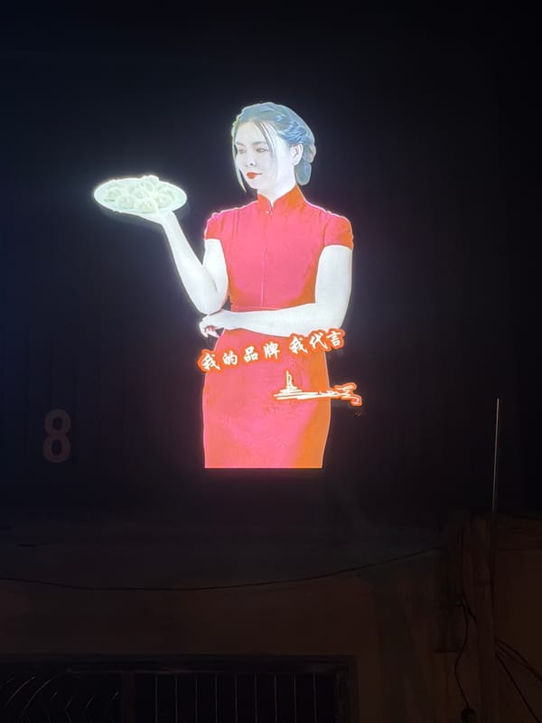 Dumpling advertisement projected on Zhongtun street amid parked vehicles