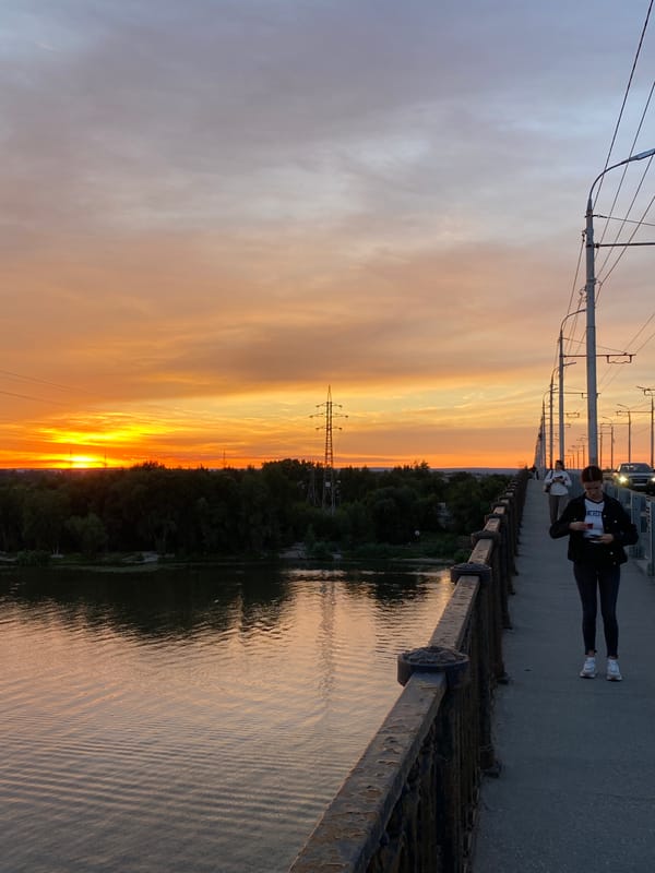Golden hour across Novokuybyshevsk — river, rooftops, and streets