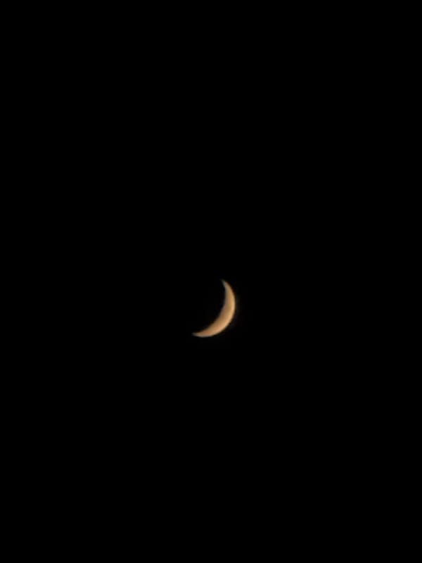 Crescent moon glowing against a dark Italian night sky