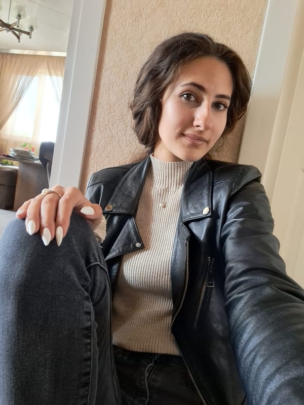Woman in black leather jacket poses for indoor photos