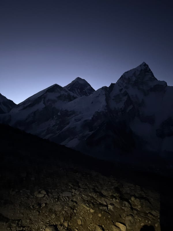Trekkers climb rocky mountain path at twilight near Khumjung
