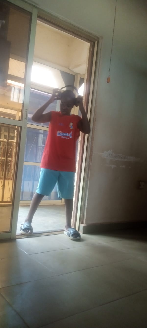 Teen dances with headphones in Yelwa building