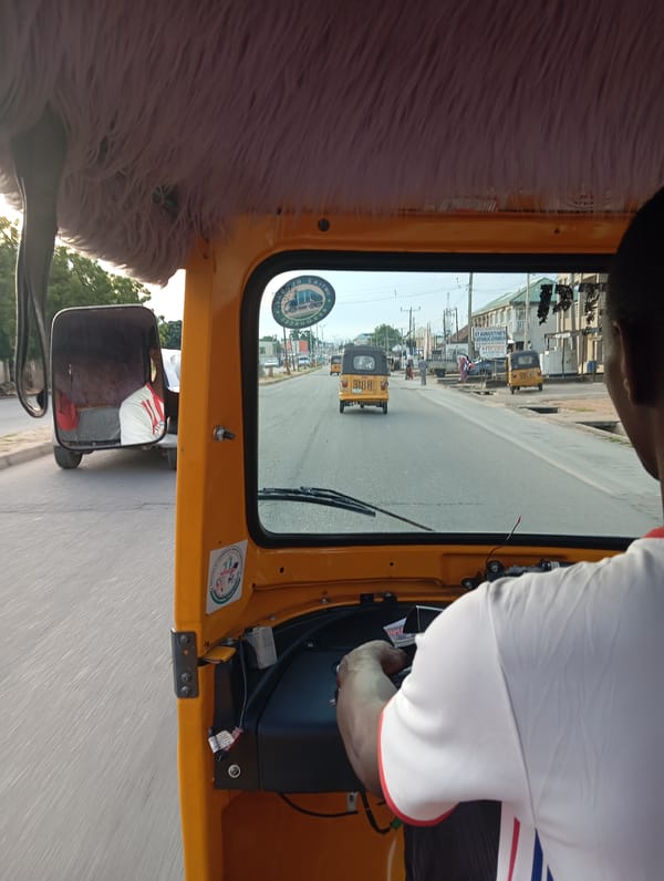 Street-level keke ride through Jalingo's busy commercial district