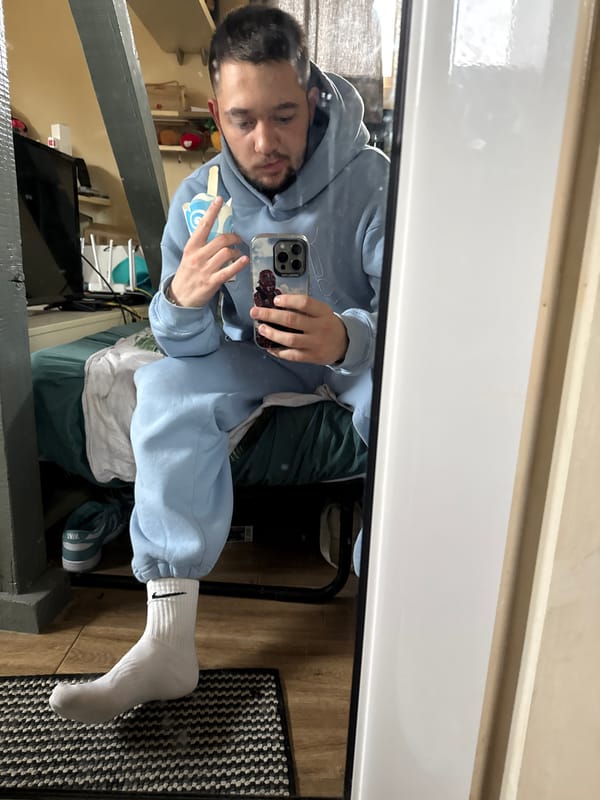 Man takes mirror selfies in light blue hoodie in Sofia
