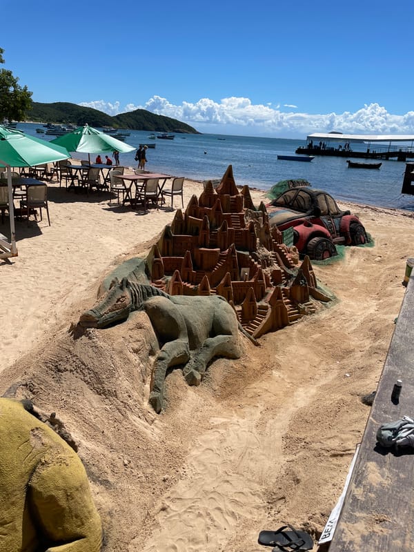 Tourists enjoy beach day with sand sculptures in Búzios