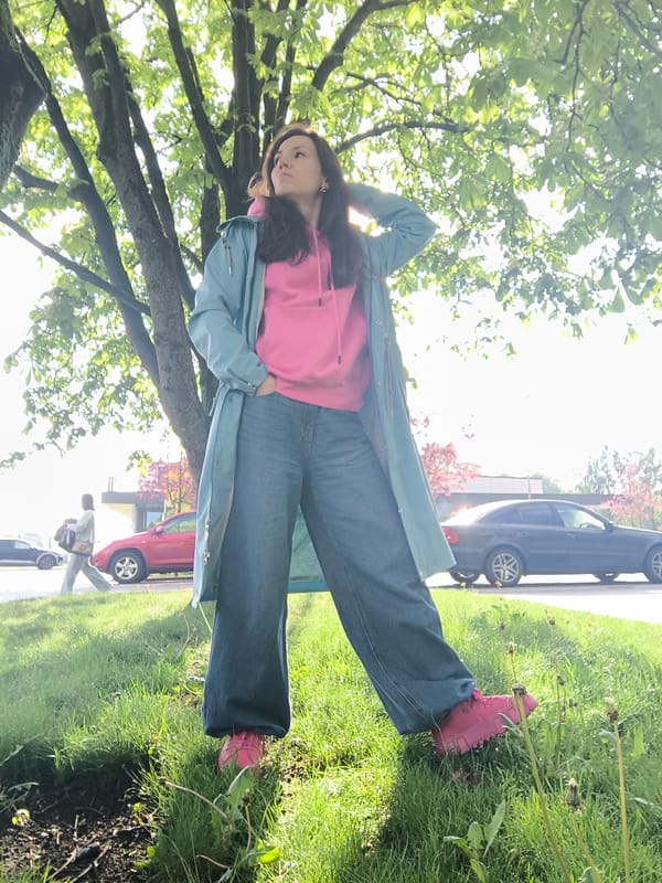 Woman in pink hoodie photographed posing around Riga