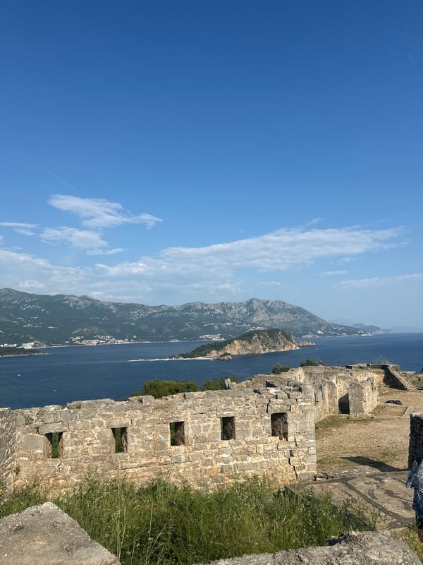 Tourist explores medieval Budva citadel, documents Adriatic coastal views