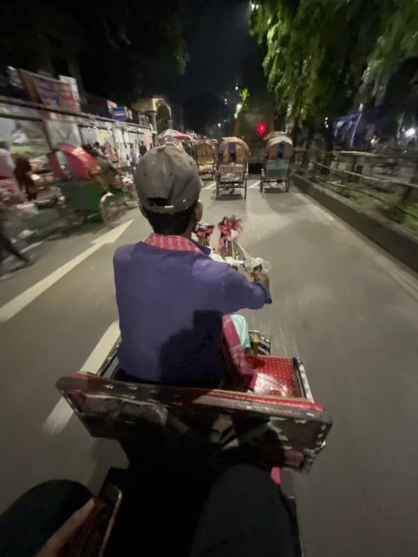Rickshaw rider travels through Dhaka streets in afternoon