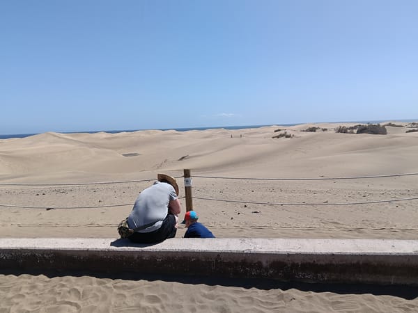 Tourists visit Maspalomas Dunes on sunny afternoon in Spain