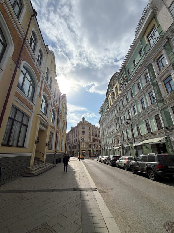 Moscow street scene shows tall buildings lining narrow roadway