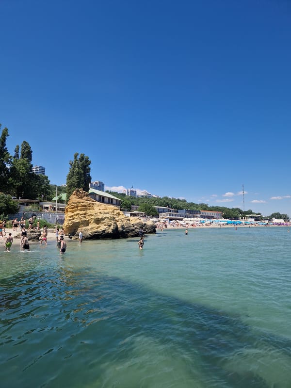 Sunny day at a concrete pier with people in the water