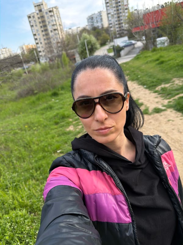 Woman takes selfies on Pleven street wearing colorful jacket