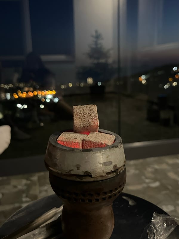 Evening hookah session captured on Baranovka balcony overlooking city