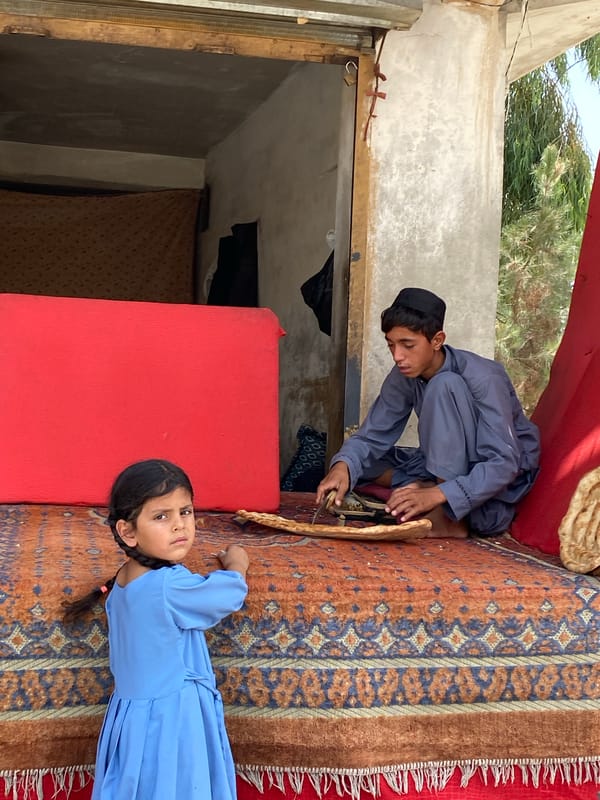 Flatbread being sliced on a colorful rug in Kandahar