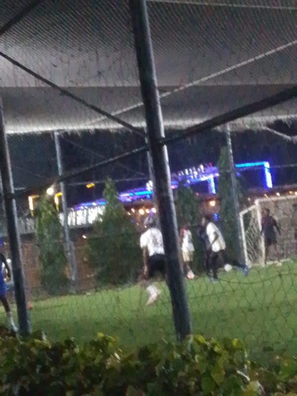 Night football on a floodlit turf pitch in Gura Top, Nigeria