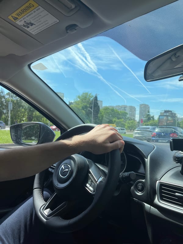 Driver photographed inside Mazda vehicle dashboard view