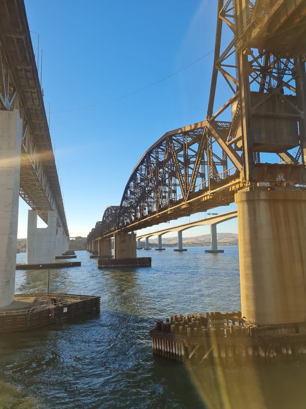 Multiple bridges cross a waterway under clear blue skies