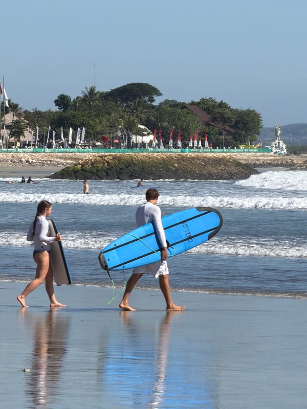 Early morning surf session underway at Kuta Beach, Bali