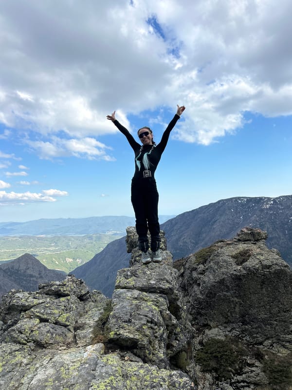 Person poses on mountain ledge in Kalofer, Bulgaria