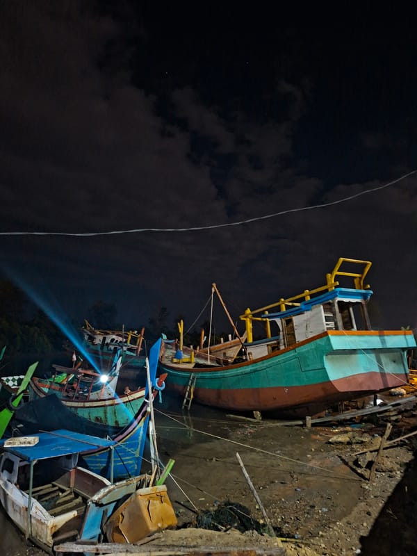 Colorful fishing boats clustered at Lhokseumawe boatyard captured at night