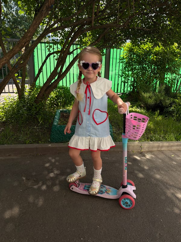 Girl with decorated sunglasses rides pink-basket scooter in Moscow