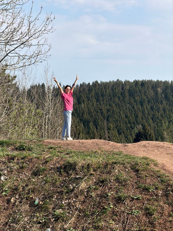 Person celebrates outdoors on Perm hillside during sunny spring day