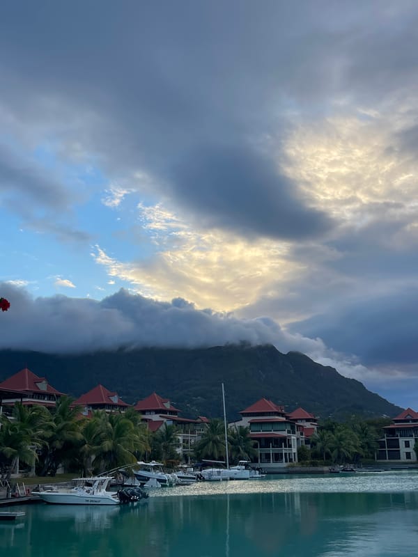 Boats moored at a calm Seychelles marina under overcast skies