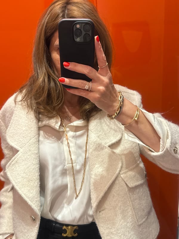 Woman takes selfie near orange wall in Lisbon