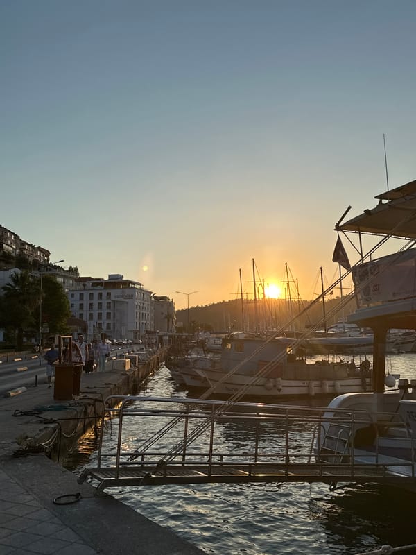 Fethiye marina at golden hour, boats, promenade, sunset.