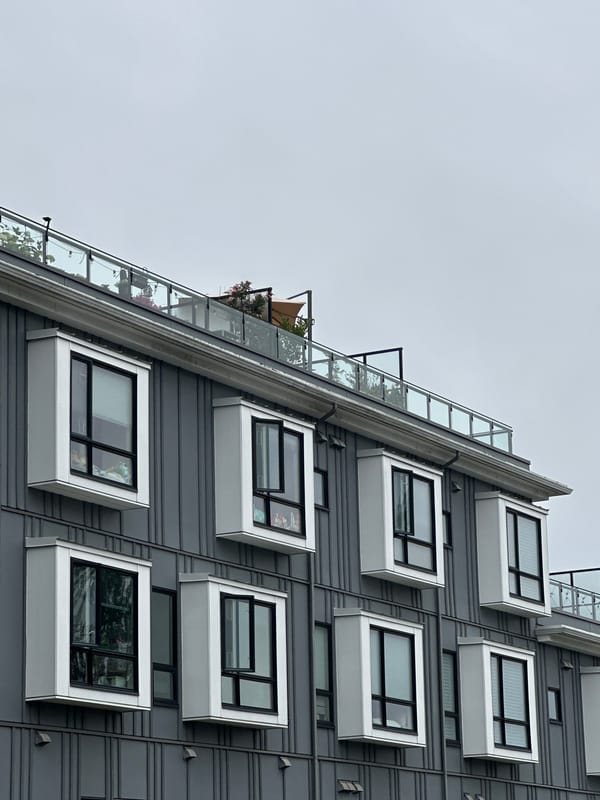 Ribbed gray apartment building with white window boxes in Burnaby