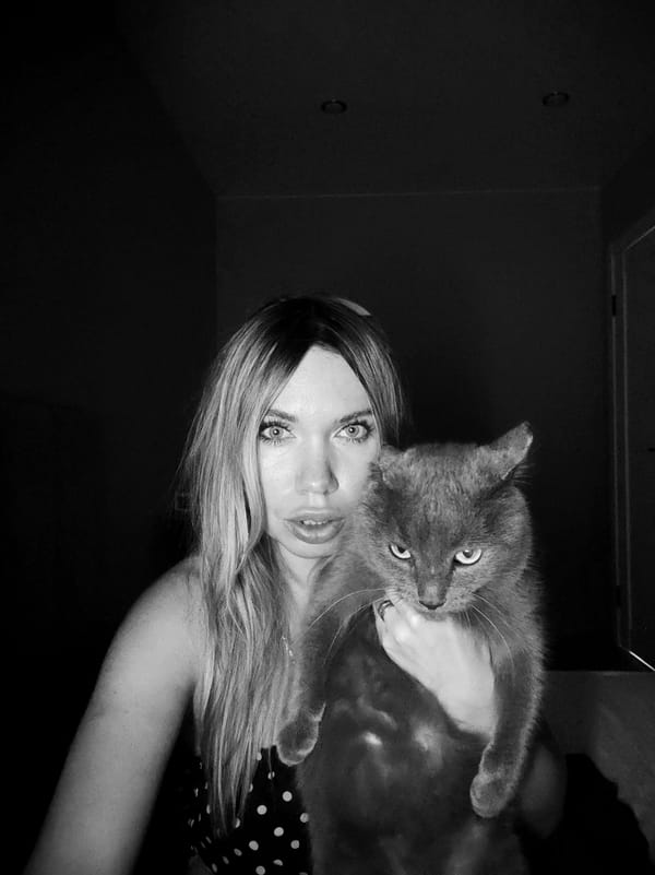 Woman with blonde hair holds grey cat in Votkinsk