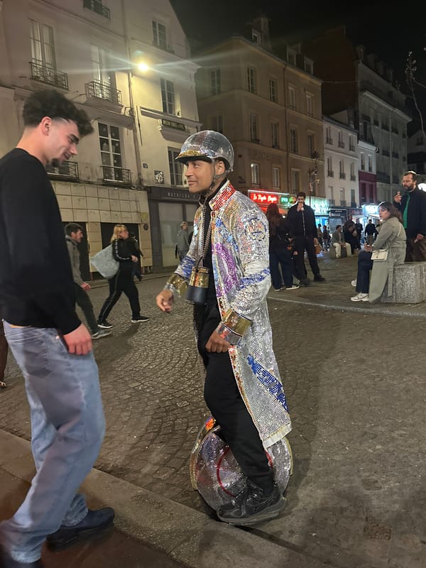 Disco-suited performer rides motorized unicycle through Paris streets