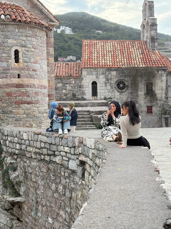 Women photograph on stone walkway in Budva with children nearby
