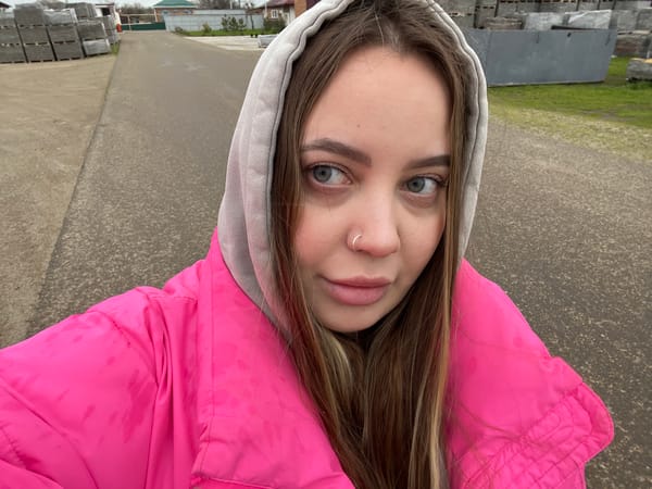 Woman takes selfies around Novopokrovskaya in pink jacket
