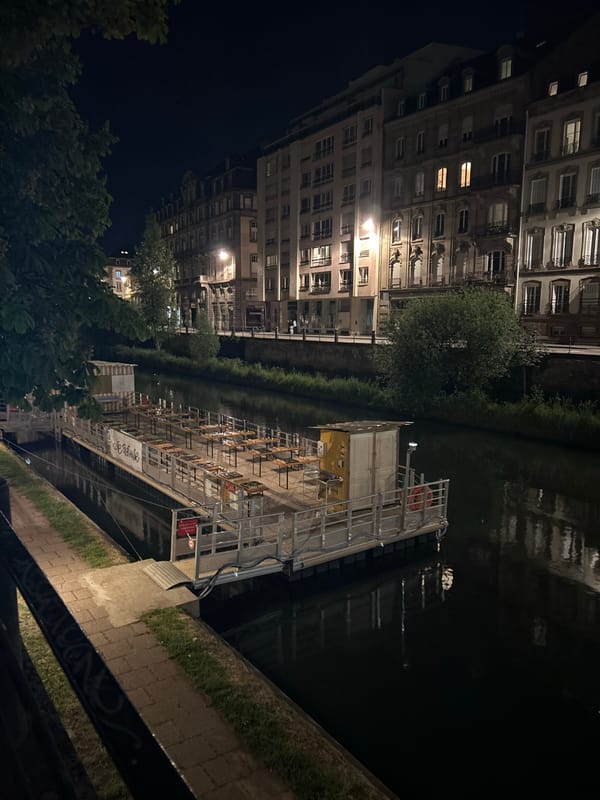 Evening stroll through illuminated Strasbourg captures canal reflections, hotels