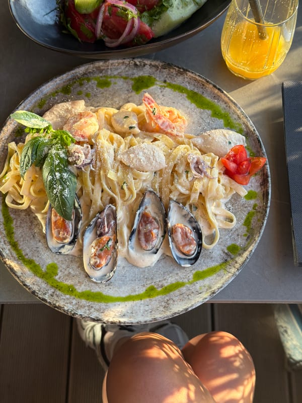 Woman enjoys seafood pasta at Montenegro coastal restaurant