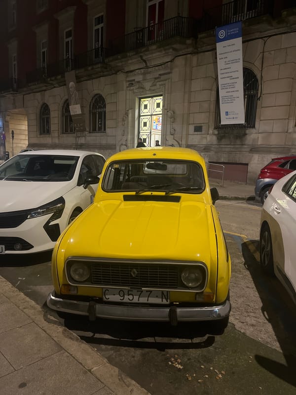 Yellow Renault 4 spotted near illuminated historical building in A Coruña