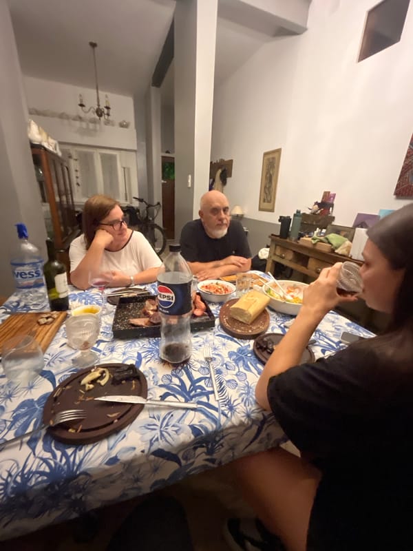 Woman drinks from cup at dining table in Avellaneda