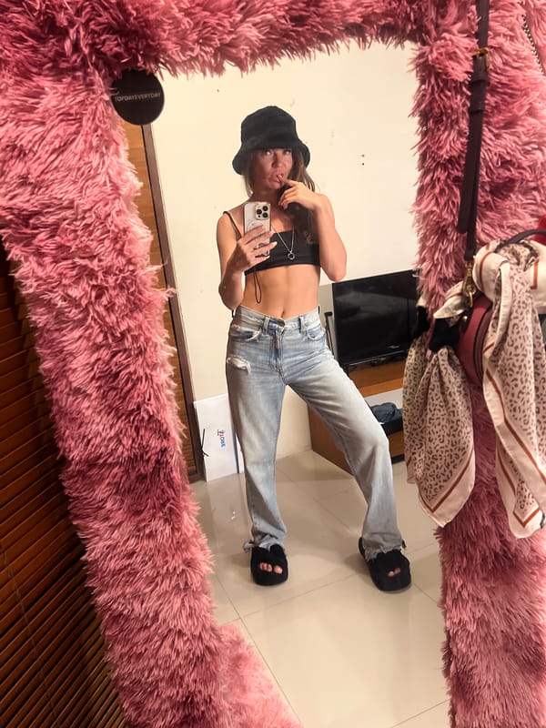 Woman takes mirror selfie in pink frame, North Kuta