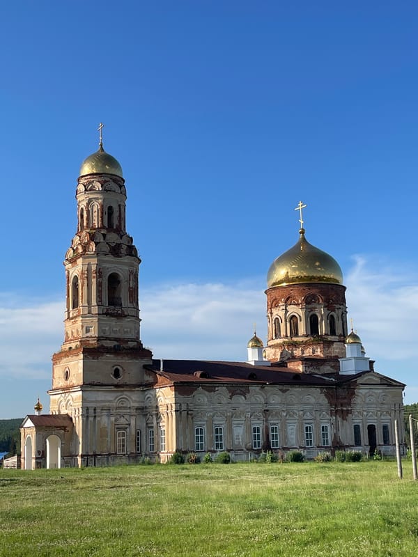 Weathered Orthodox church with golden domes in rural Russia