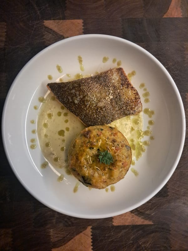 Plated fish dish with savory cake photographed in Vicente López